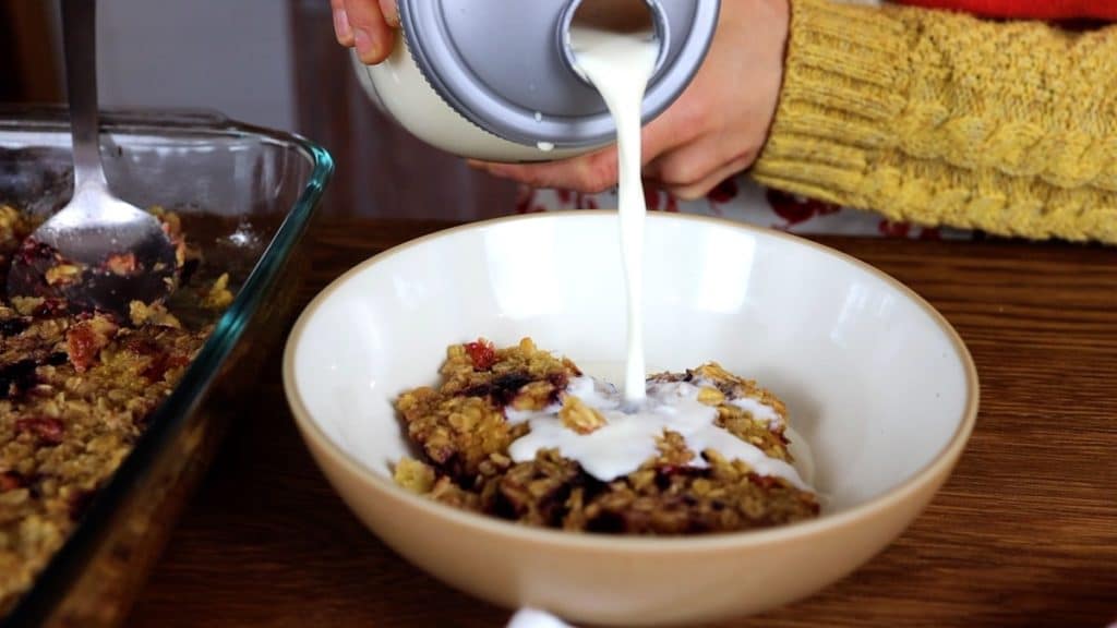 pouring milk over soaked baked oatmeal