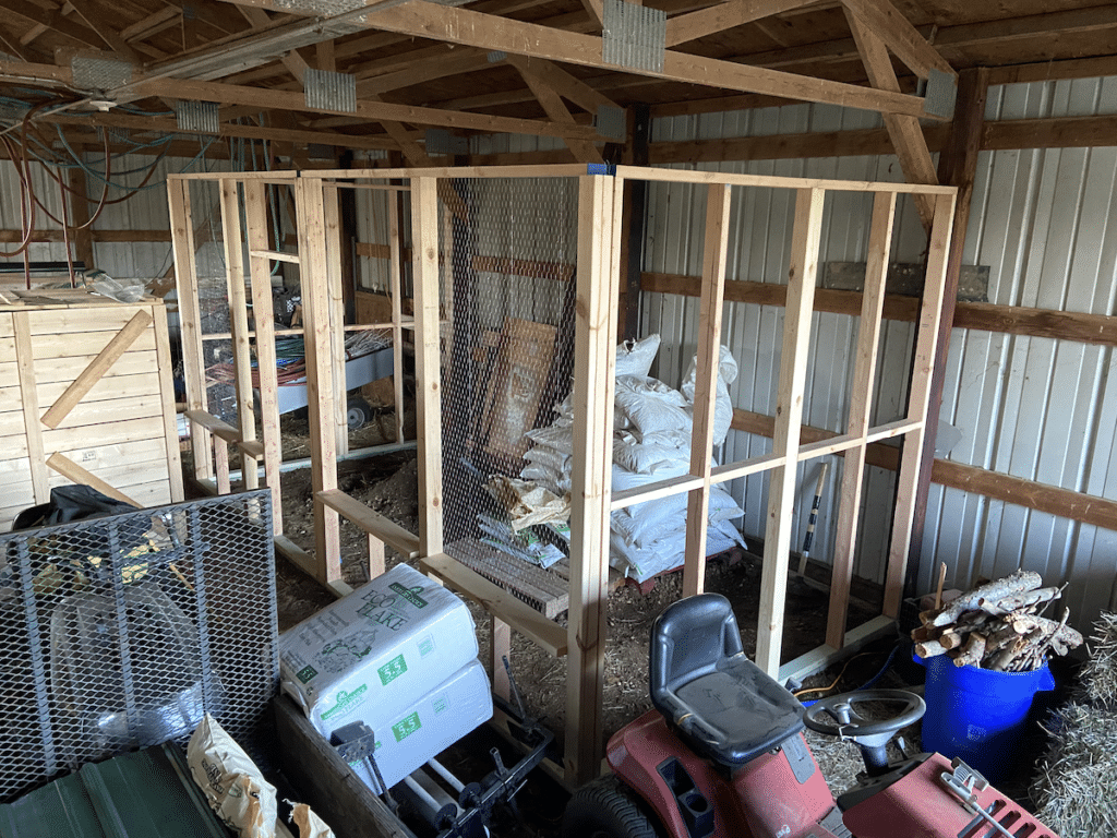 assembling walls of chicken coop inside barn