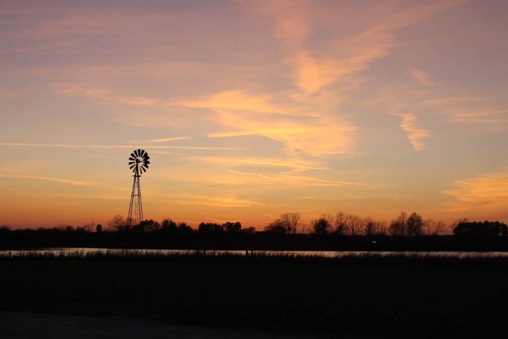 sunset farm scene with windmill