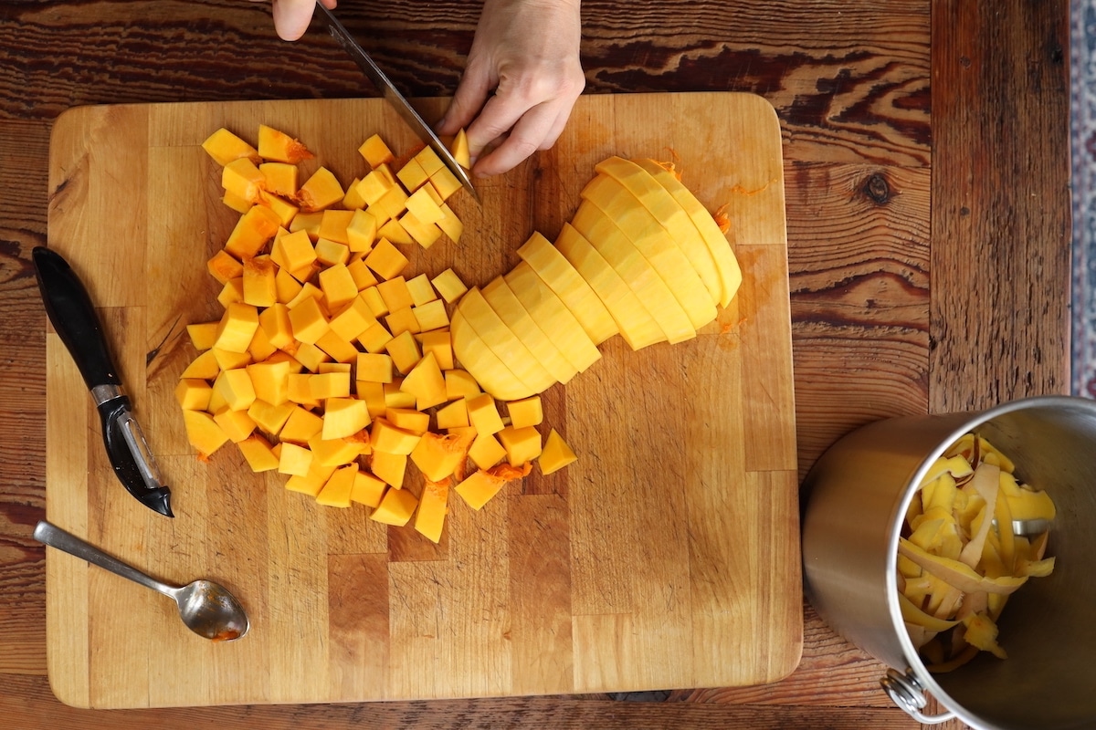 cutting butternut squash into cubes for roasting