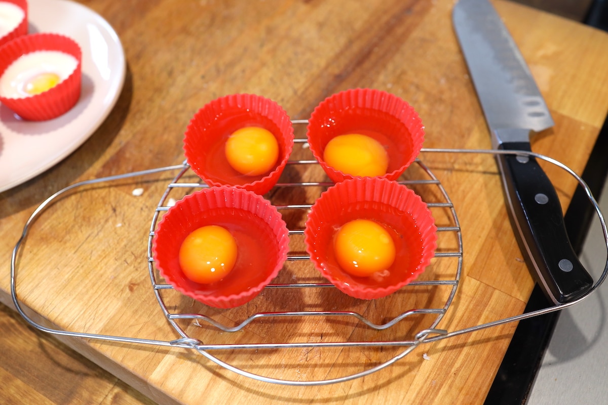 cracking eggs into cups for pressure cooked pached eggs