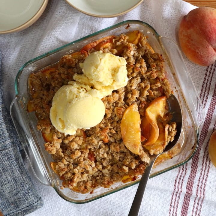 serving peach crumble with oats and ice cream