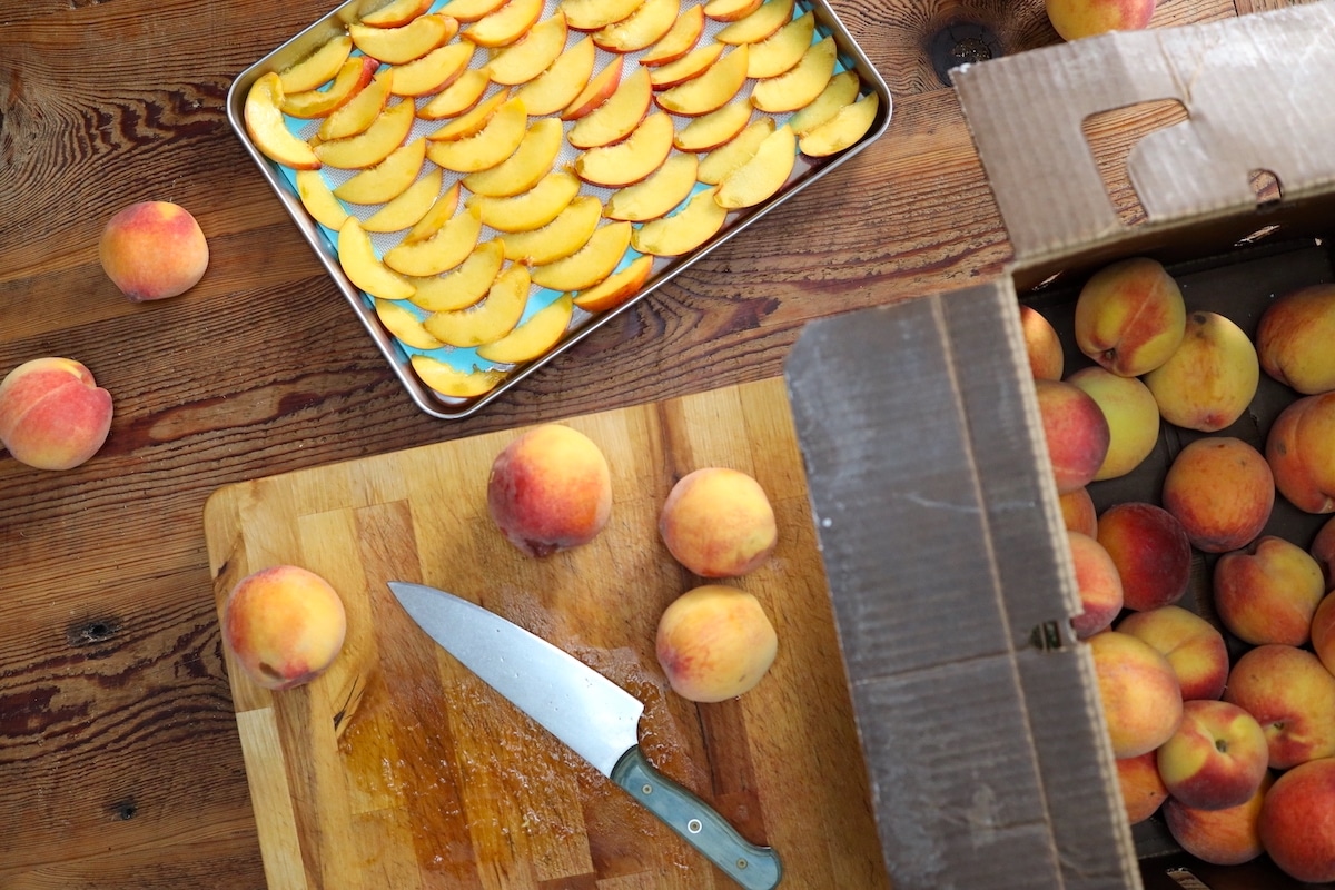 slicing peaches to freeze on cookie sheet