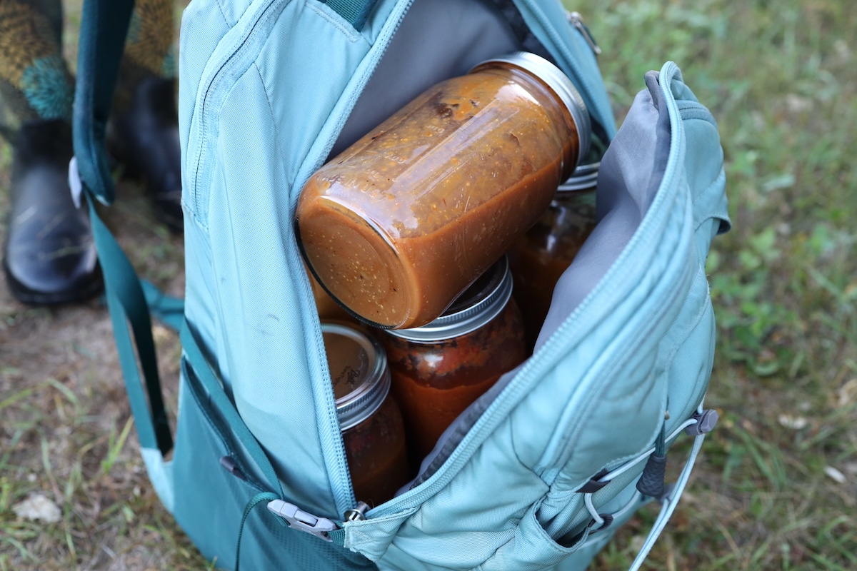 makeshift rucksack with jars of tomato sauce