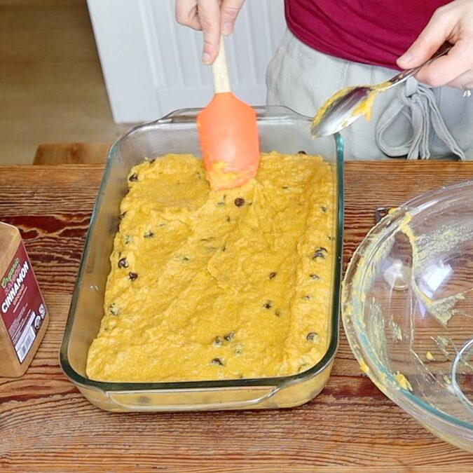 spreading gluten free pumpkin cake batter in pan