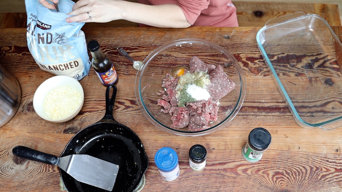 adding spices and almond flour to meatloaf mix