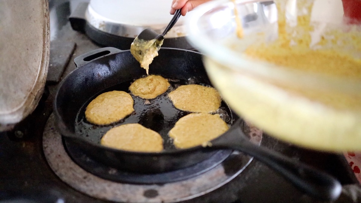 pouring pancake batter into cast iron pan