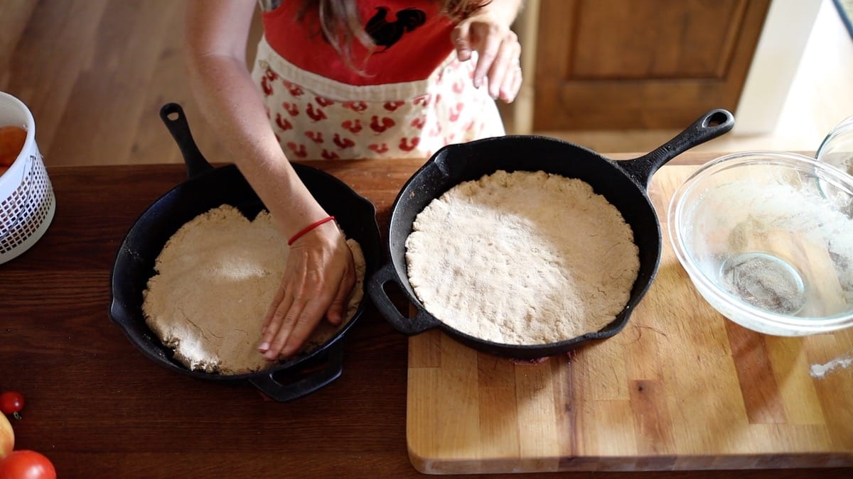 2 homemade pizza doughs in cast iron pans