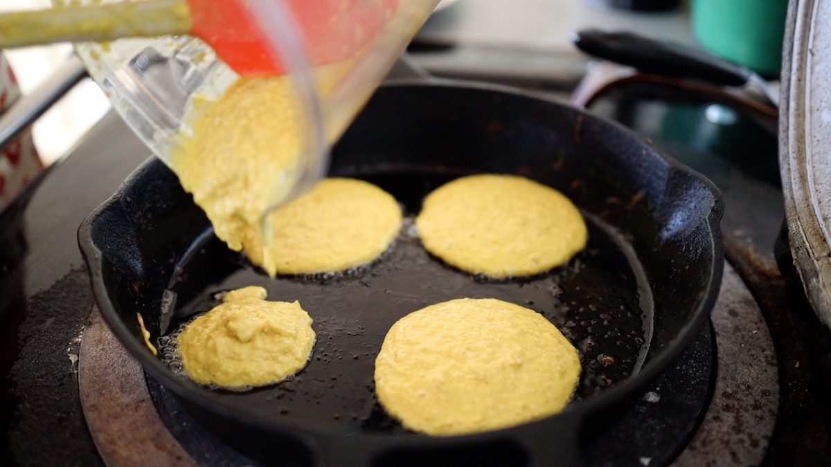 pouring pancake batter into pan