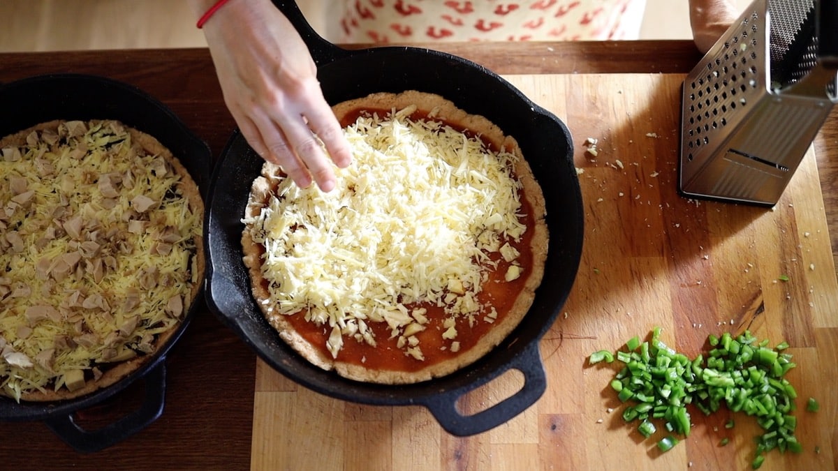 spreading cheese on pizza