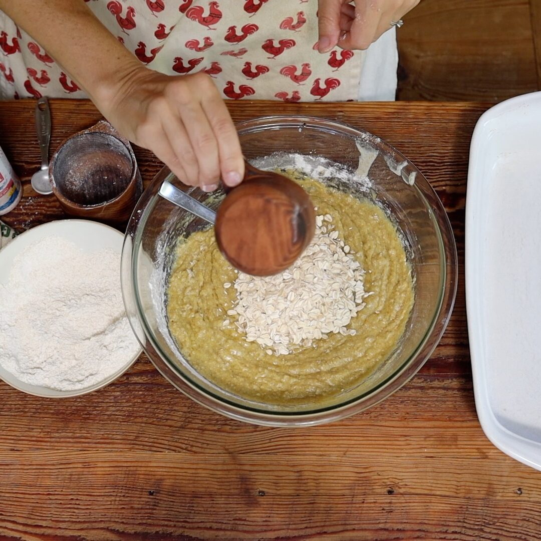 dumping in oats to cookie bar batter