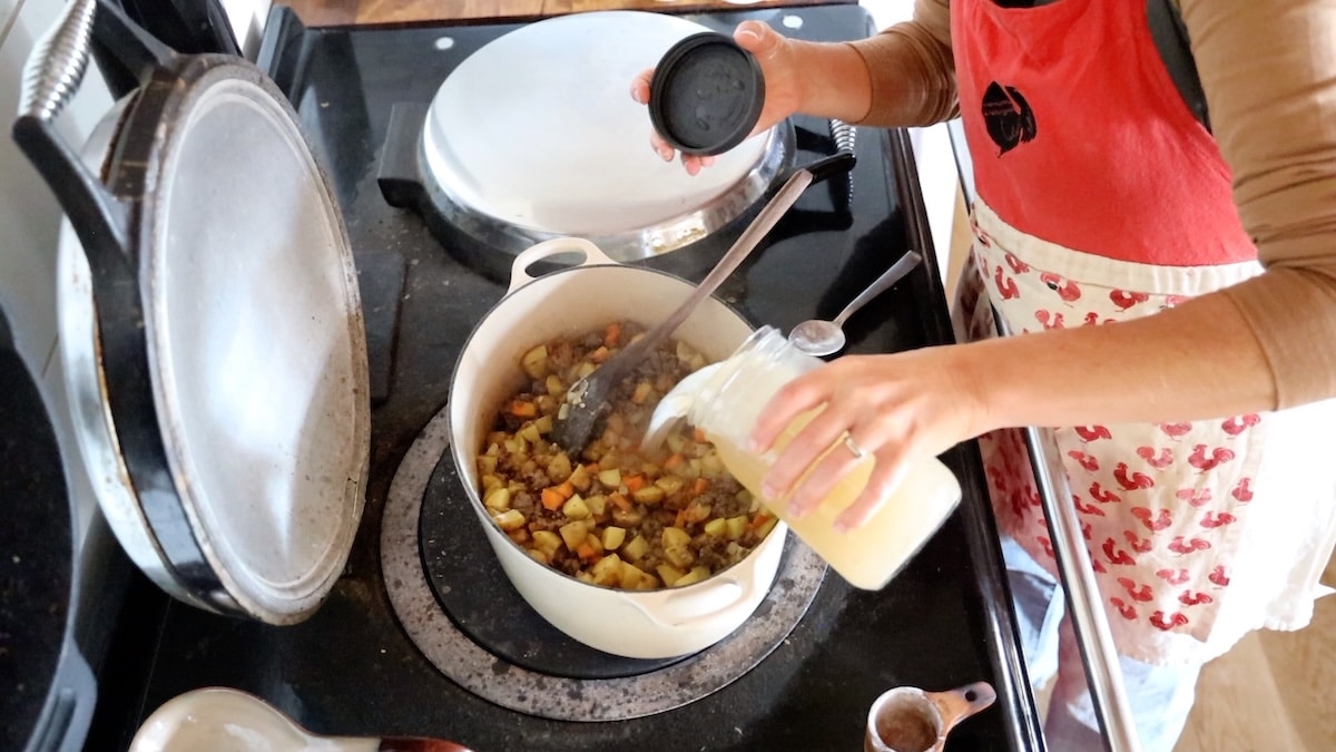 adding broth to soup