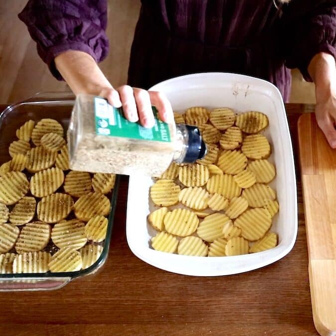 adding seasonings to crinkle cut potatoes