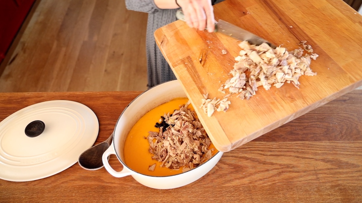 adding chopped chicken to soup