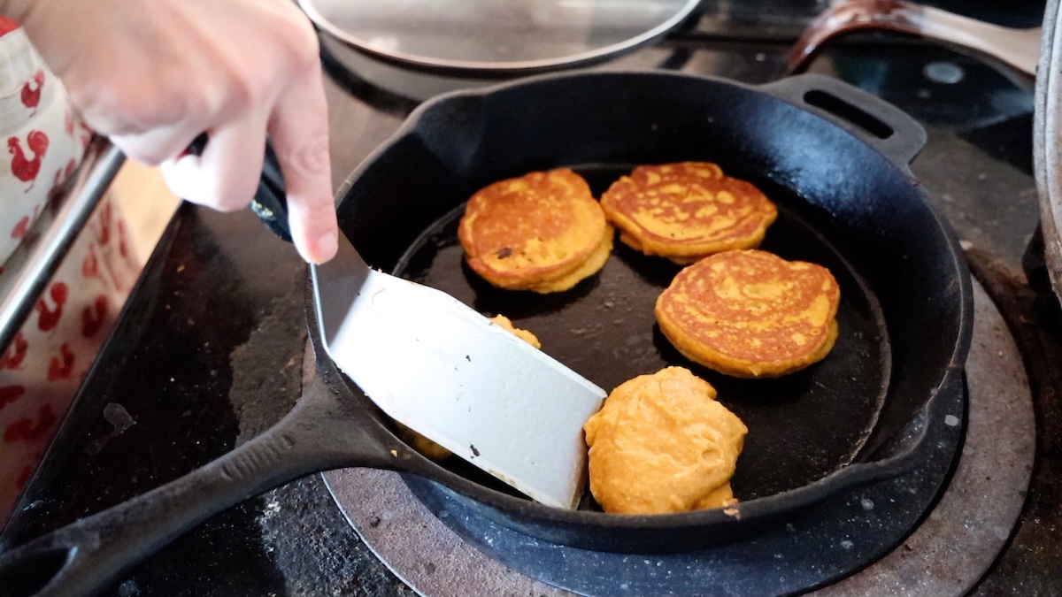 flipping oatmeal pumpkin pancakes in cast iron pan