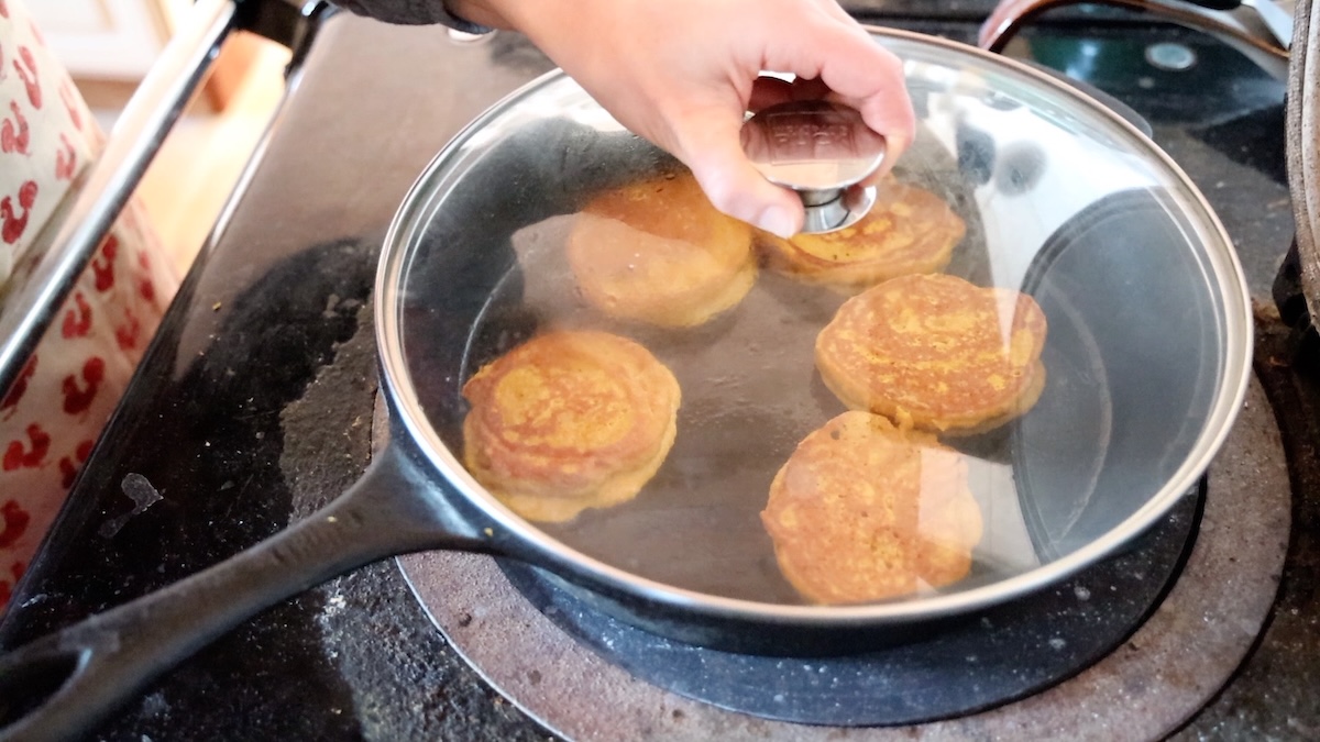 putting lid over pumpkin pancakes while cooking