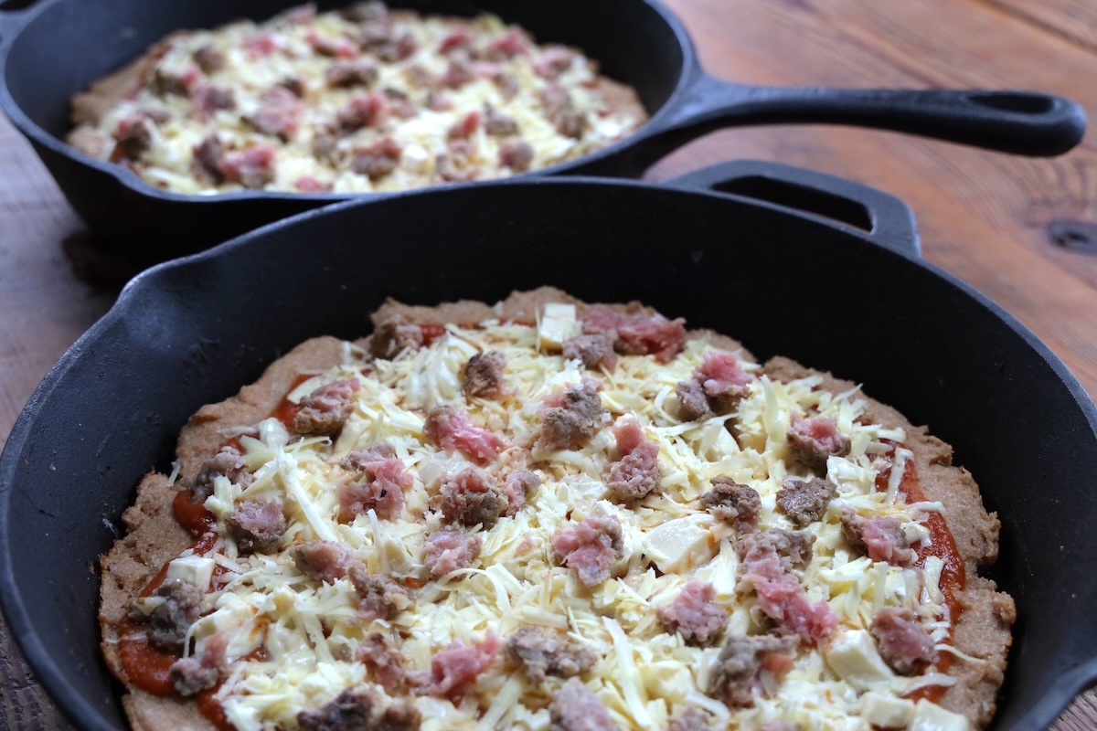 cast iron pan pizzas ready to bake