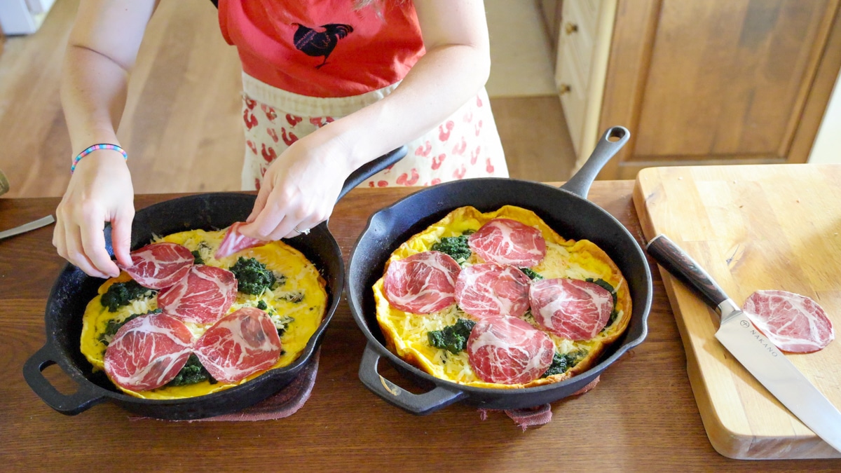adding meat on top of savory dutch pancake