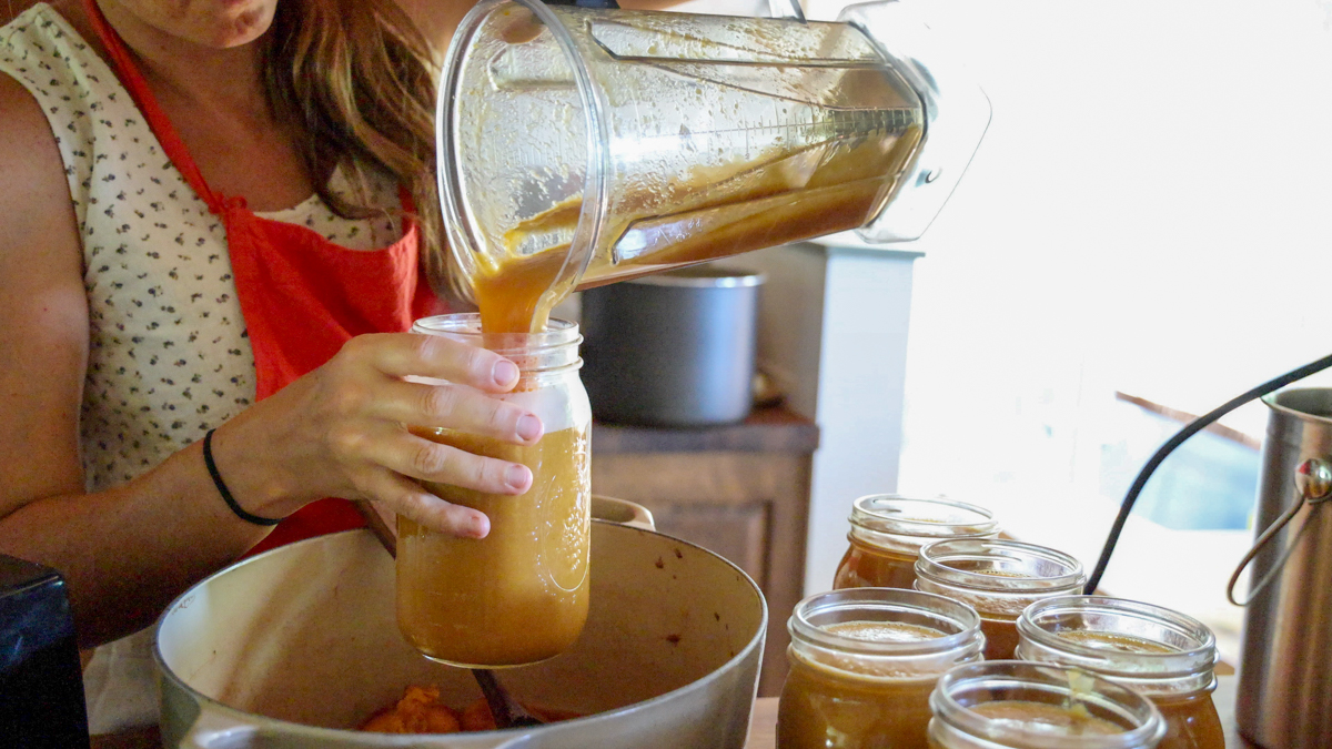 pouring peach sauce into jars