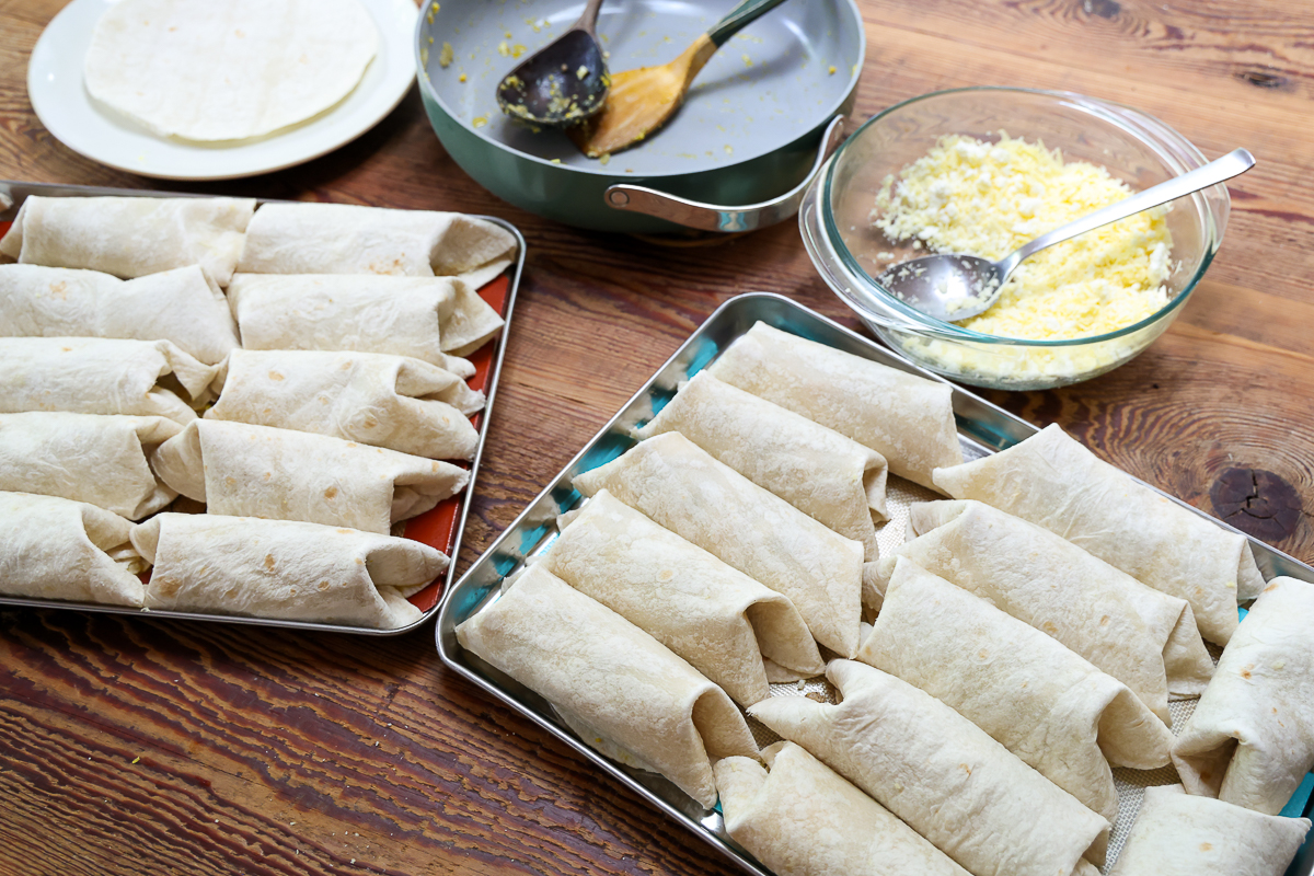 simple breakfast burritos on a baking sheet