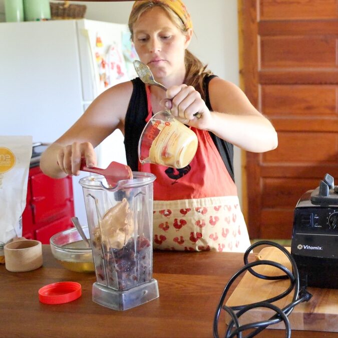 adding peanut butter to blender for date energy balls