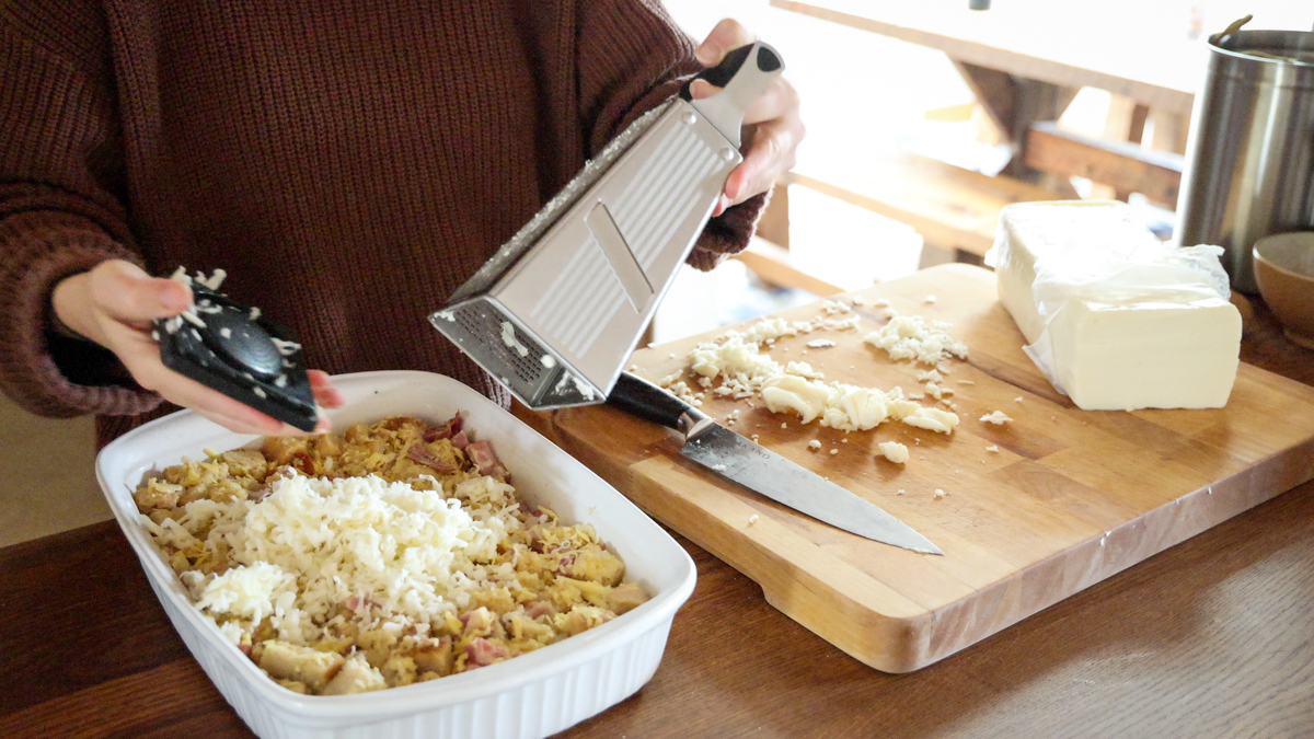 topping strata with shredded cheese