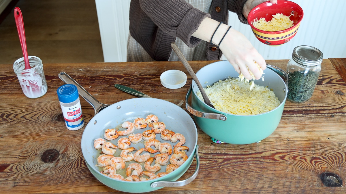 adding cheese to shrimp and rice recipe pot