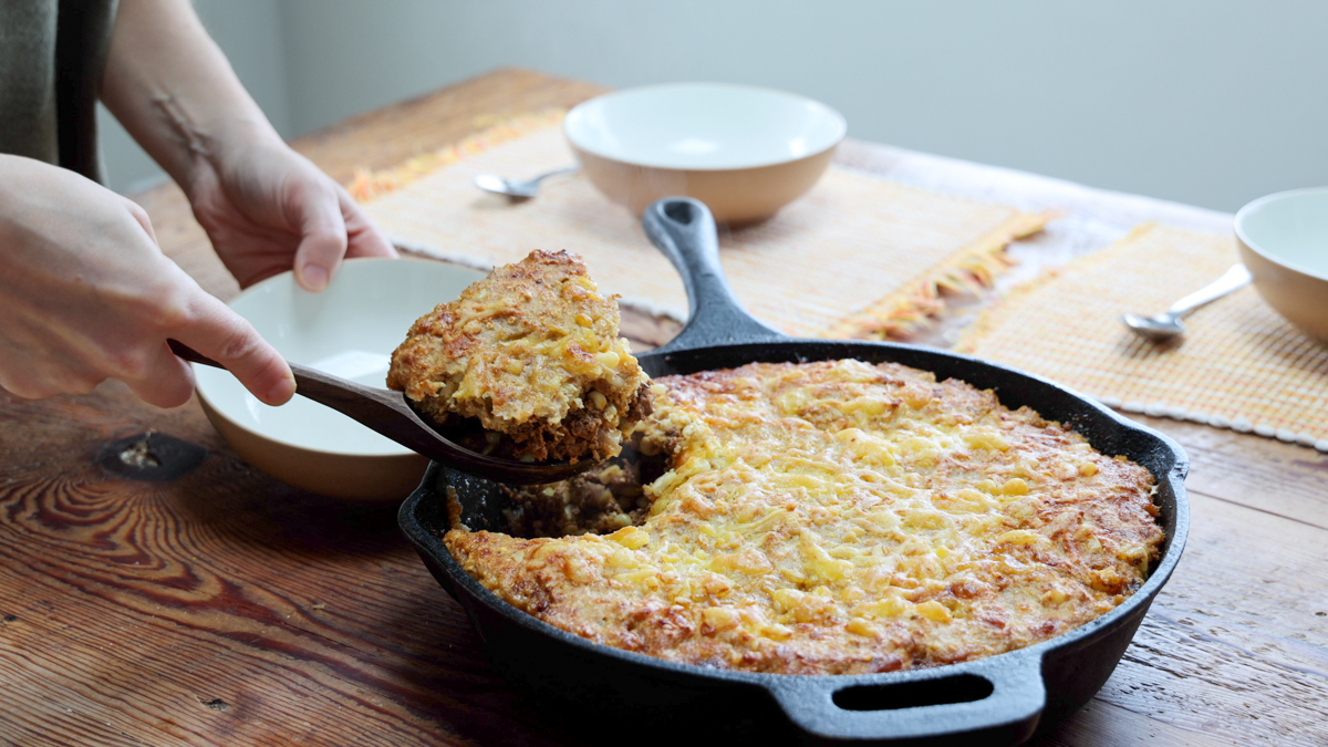 scooping tamale casserole from pan