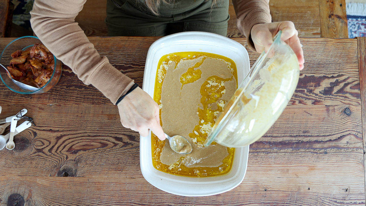 pouring batter over melted butter for easy peach cobbler