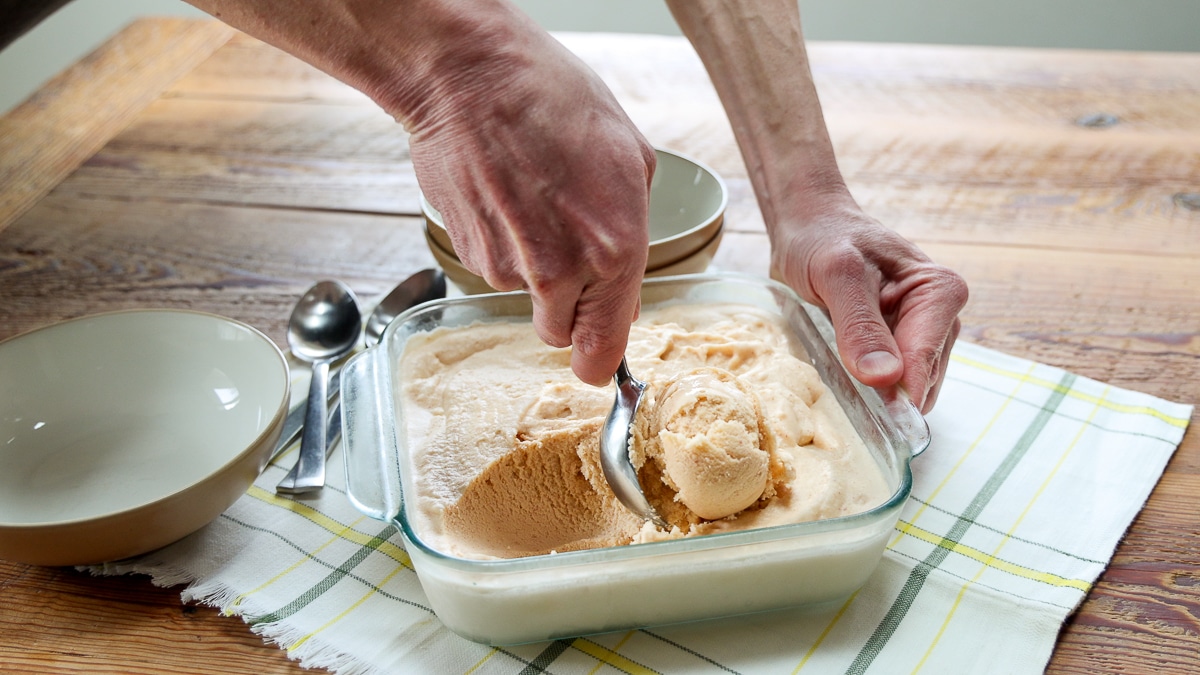 scooping homemade peach ice cream