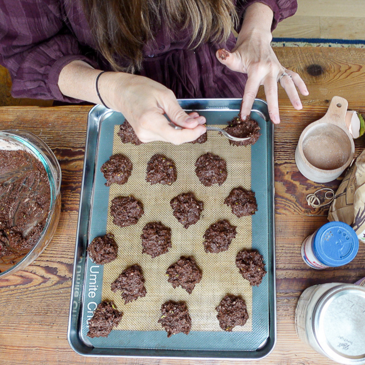 spooning avocado cookies batter onto baking tray