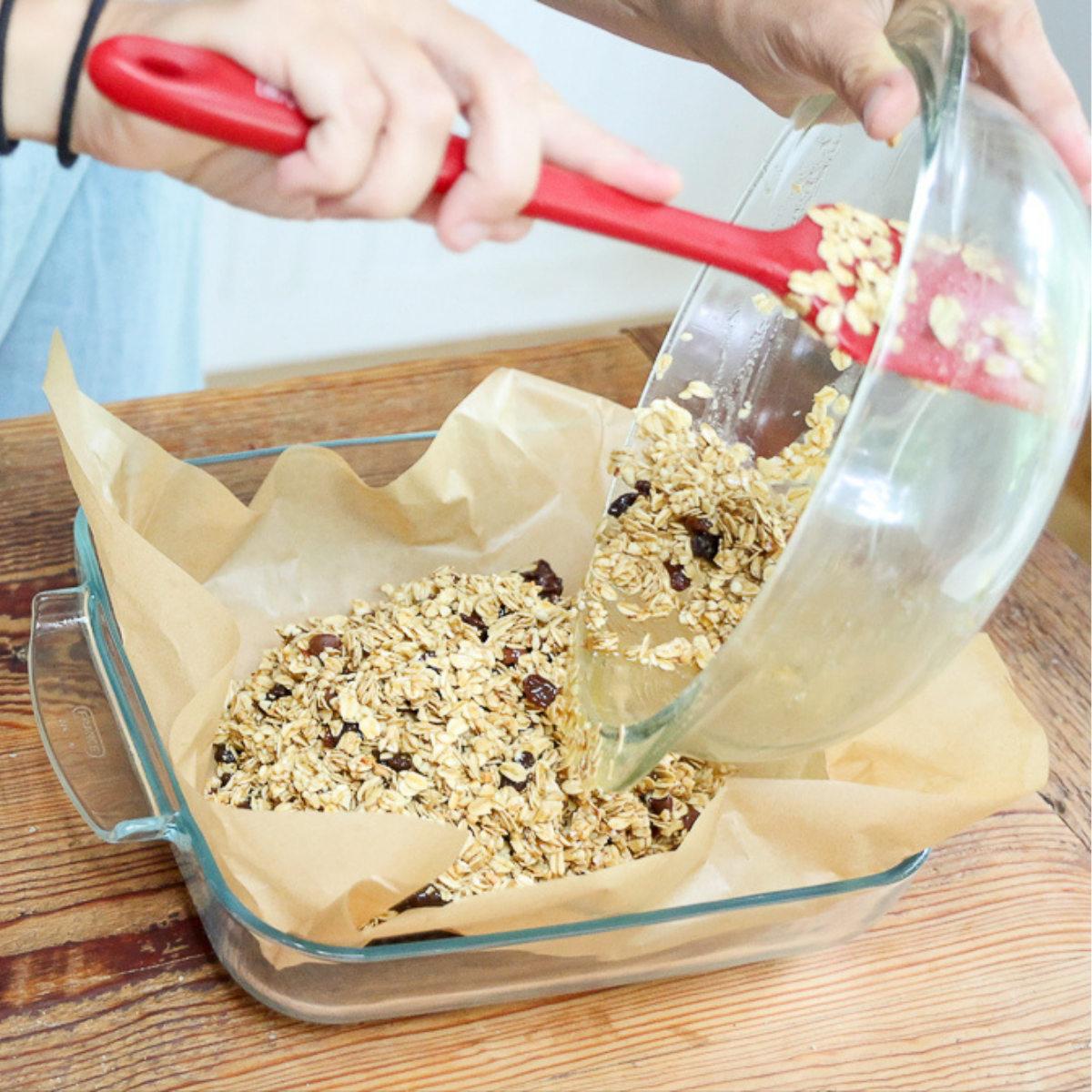 pouring homemade granola bars without peanut butter mixture into pan