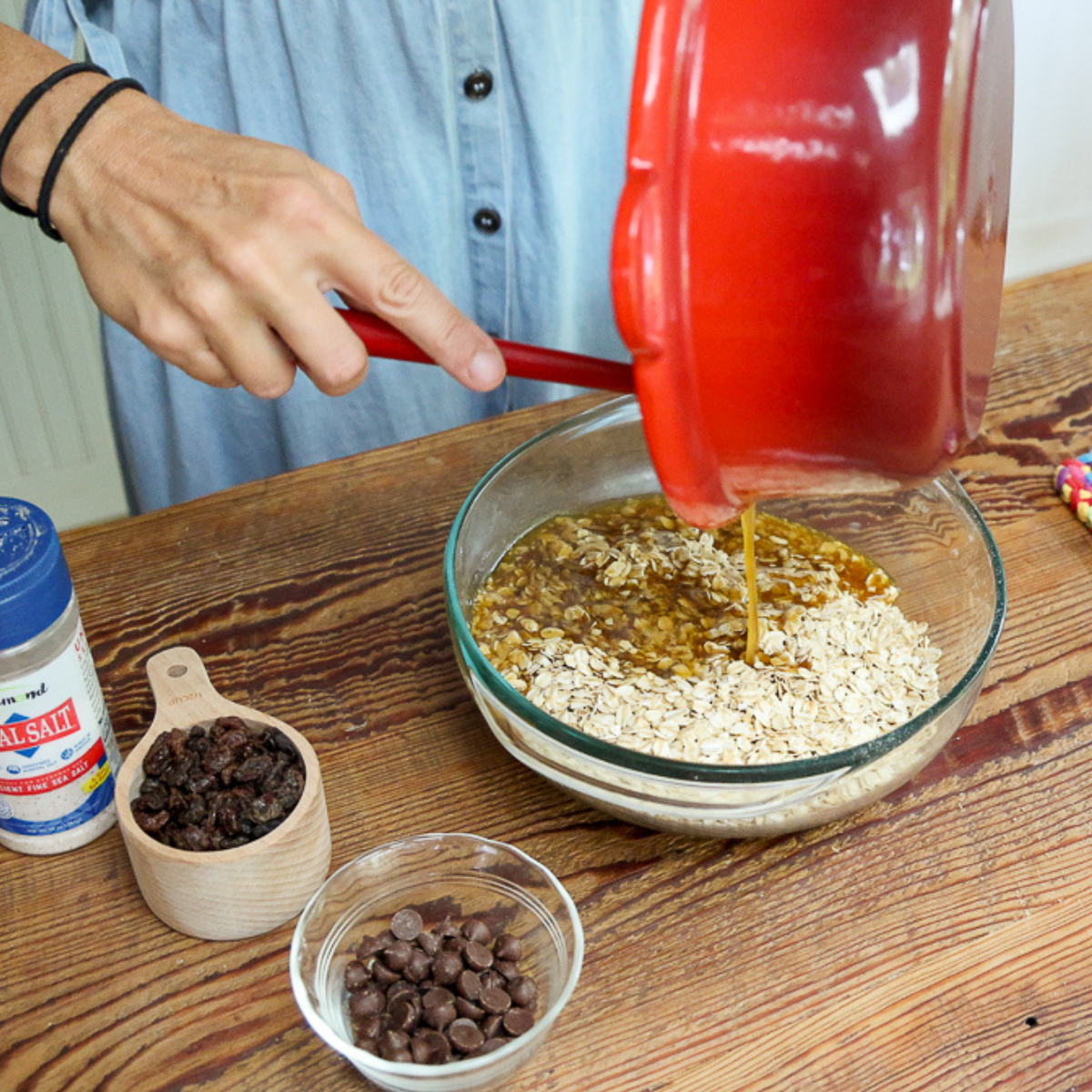 pouring syrup over oat mixture for homemade granola bars without peanut butter