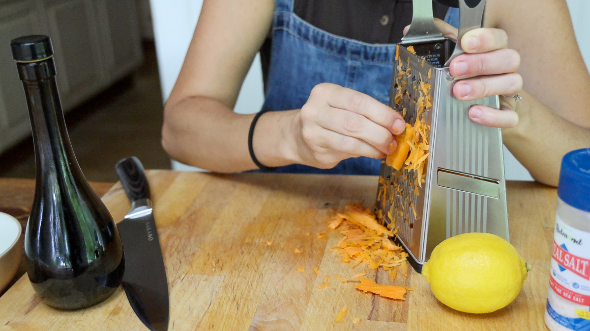 shredding carrot for raw carrot salad